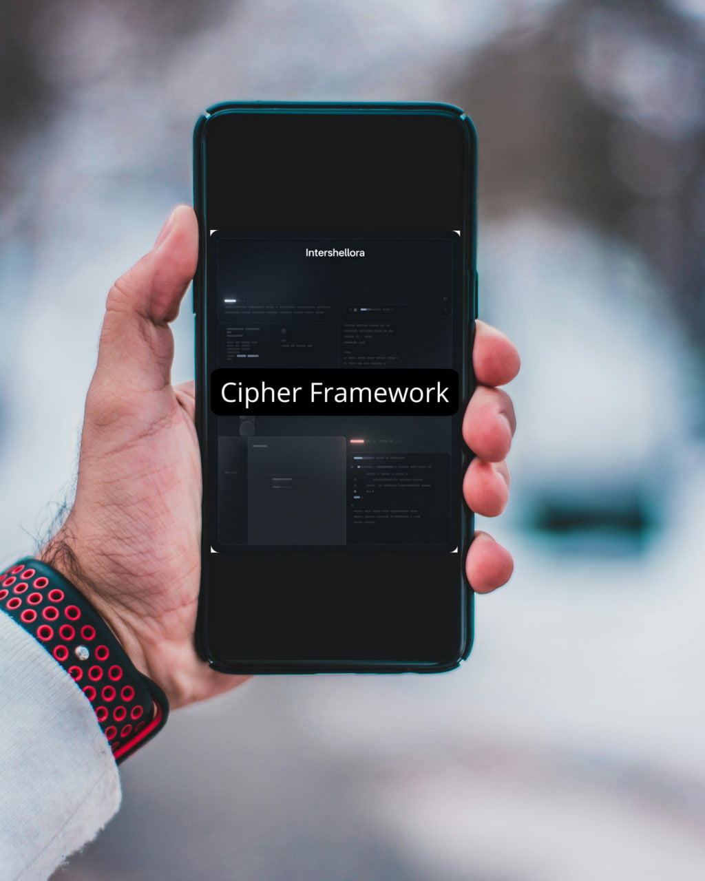 Hand holding a smartphone displaying 'Cipher Framework' with a blurred outdoor background